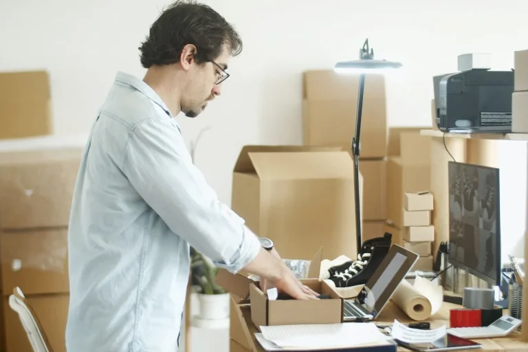 Un homme range des cartons dans un bureau