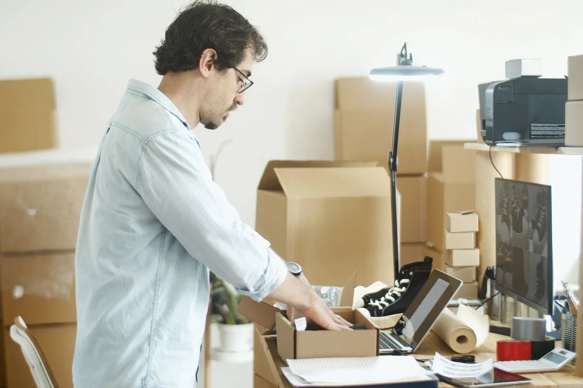 Un homme range des cartons dans un bureau