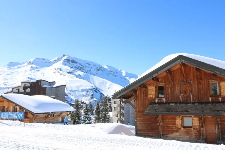 Chalets en bois enneigés au pied des pistes d'une station de ski